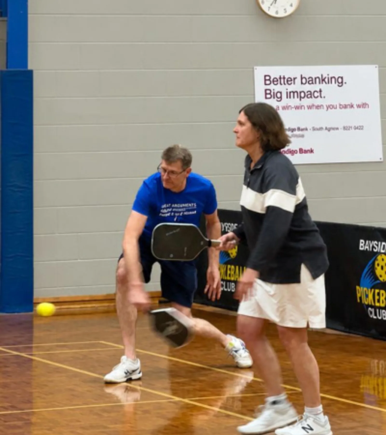 Bayside players returning a shot during an indoor doubles game